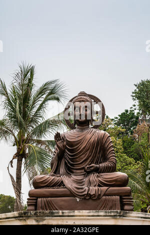 Si Racha, Thailand - März 16, 2019: Nahaufnahme von Bronze Statue sitzend erleuchtet, mitleidsvollen Bodhisattvas mit Halo auf Ko Loi Insel unter Silve Stockfoto