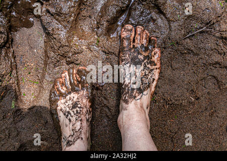 Eine Top-down-Sicht auf ein Barfuß stehenden Person in der Heiligen Matsch und Schlamm bei einer Outdoor Retreat feiern Schamanische und einheimischen Kulturen. Stockfoto