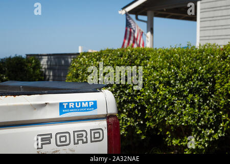 LINCOLN CITY, OR, USA - 26.August 2019: ein Ford Pickup Truck mit einem pro Trump Autoaufkleber und eine amerikanische Flagge im Hintergrund. Stockfoto