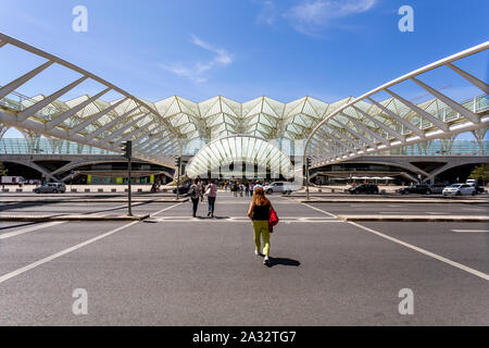 Menschen, die über die Straße vom und zum Bahnhof Oriente, Eisenbahn und Bus Drehscheibe in Lissabon, Portugal Stockfoto