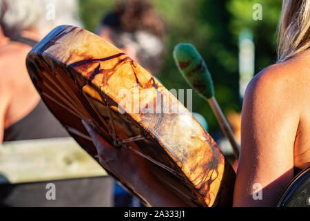 Eine bunte Leder drum in Native American Style ist ganz nah gesehen und von der Seite bei einem Gig im Freien feiern traditioneller Musik. Stockfoto