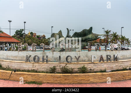 Si Racha, Thailand - 16. März 2019: Koh Loy Park Schild am Brunnen mit Bronze Statuen der Schwertfische unter blauem Himmel mit grünem Laub und Rot Stockfoto