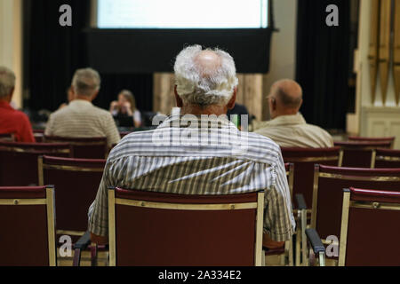 Eine Nahaufnahme und Rückseite auf der Rückseite des Kopfes einen älteren Mann, mit grauem Haar und kahle Stelle, während ein Dorf der Gemeinde. Stockfoto