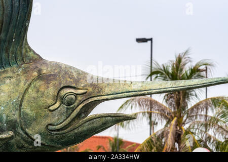 Si Racha, Thailand - März 16, 2019: Nahaufnahme von Leiter der Statuen aus Bronze Schwertfisch in Koh Loy Park Brunnen unter Silber Himmel mit grünem Laub und r Stockfoto