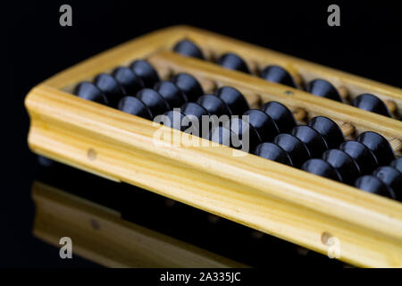 Abacus mit schwarzen Perlen auf Schwarz reflektierende Oberfläche Stockfoto