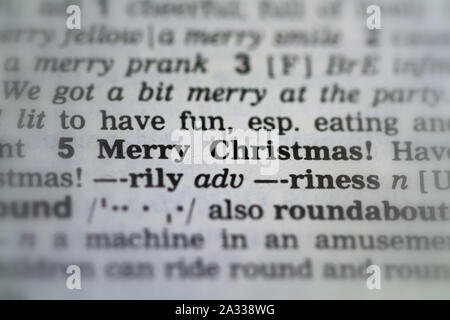 Das Wort frohe Weihnachten Definition in alte Wörterbuch unter der Lupe Stockfoto