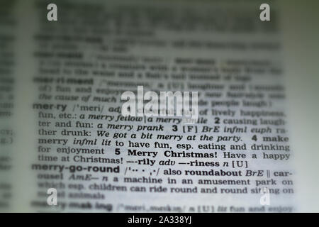 Das Wort frohe Weihnachten Definition in alte Wörterbuch unter der Lupe Stockfoto