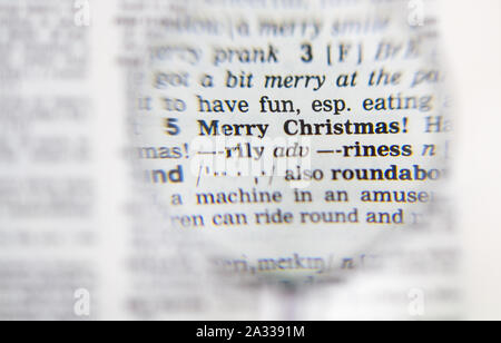 Das Wort frohe Weihnachten Definition in alte Wörterbuch unter der Lupe Stockfoto