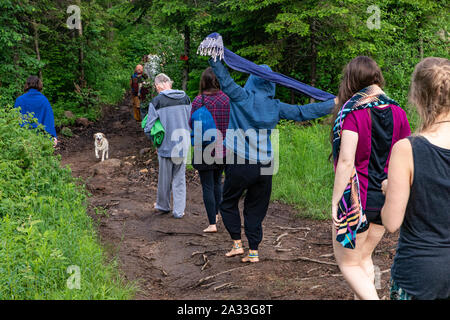 Eine generationenübergreifende Gruppe von Menschen gesehen, die Natur erleben und Achtsamkeit während einer Woodland retreat Feiern multikulturellen Überzeugungen. Stockfoto