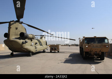 Eine CH-47 Chinook aus der im Expeditionary Combat Aviation Brigade, wartet getankt werden, während auf dem Asphalt, Camp Taji, Irak, Sept. 23, 2019. Die im ECAB ist der erste US-Army Reserve Aviation Brigade durch aktive und National Guard Soldaten für ihre Bereitstellung zu ergänzt werden. (Schwanz Nummer für die operationelle Sicherheit ausgebaut) (U.S. Armee finden Foto Grafik: Spc Ashton Koller) Stockfoto