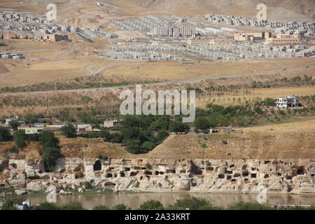 09. September 2019, in der Türkei, in Hasankeyf: Jahrtausende alte Wohn- Höhlen in den Vordergrund und die neue, moderne Stadt Hasankeyf. Die angeblich 12.000 Jahre alte Siedlung liegt unter dem Wasserspiegel des ein riesiges Reservoir bis Ende des Jahres zu sinken. Etwa 70 Kilometer weiter flussabwärts, der ilisu Megadam hat begonnen Arbeit und hat stauen Wasser seit mehreren Wochen. Nach Angaben der örtlichen Behörden, im Herzen der kleinen Stadt Zentrum ist evakuiert werden und zum Teil vom 8. Oktober abgerissen. Die Menschen müssen die Neustadt, die Sie für eine lange Zeit boykottiert hatte zu bewegen. Foto: Christine Stockfoto