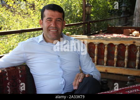 09. September 2019, in der Türkei, in Hasankeyf: Regierung Politiker Ömer Güzel von der AKP-Partei sitzt in einem Restaurant in der Altstadt von Hasankeyf. Er ist schon lange ein Gegner des Ilisu-staudamms, die bald Flut alte Hasankeyf, aber jetzt befürwortet. Auch nach der Überschwemmung von seinem malerischen Heimatstadt, die Touristen sicherlich weiter, sagt er. Viele Projekte sind geplant, vom Tauchen Tourismus Wanderwege. In Neustadt, Menschen könnten auch mehr modernes Leben und haben mehr Platz. Alt-Hasankeyf liegt in einer einzigartigen Kulturlandschaft auf den Tigris. Menschen haben sollte zu vereinbaren Stockfoto