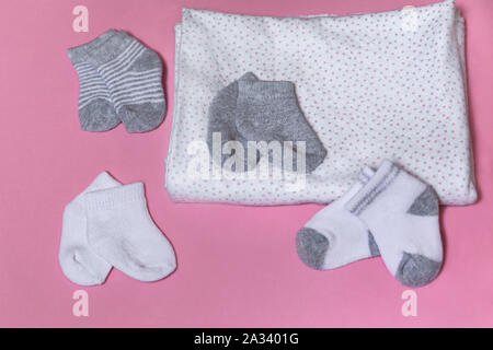 Baby Socken für neugeborene Mädchen oder Junge auf einem rosa Hintergrund, Schwangerschaft und Baby Konzept - Bild gesammelt Stockfoto
