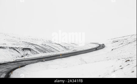 Bergauf Kurve Straße mit seitlichen Weg voll Schnee im Winter Stockfoto