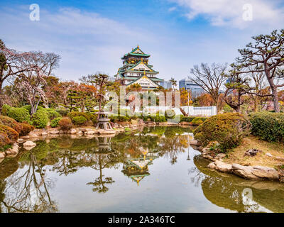 Der Bergfried der Burg von Osaka, Osaka, Japan, in einem Pool in der Anlage wider. Stockfoto