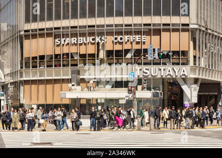 9. April 2019: Tokyo, Japan - Masse von Menschen warten auf der Straße bei Shibuya Crossing zu überschreiten, mit Starbucks Kaffee hinter Ihnen. Stockfoto