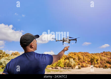 Man startet eine Drohne aus seiner Hand Stockfoto