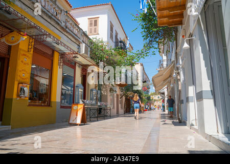 NAFPLIO GRIECHENLAND - 18 Juli 2019; griechische Dorf von Nafplio street Szene mit einer Frau zu Fuß und Einheimische und Touristen in der Entfernung. Stockfoto