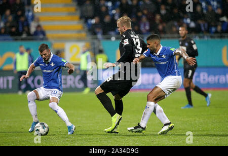 Darmstadt, Deutschland. 04 Okt, 2019. 04. Oktober 2019, Hessen, Darmstadt: Fußball-Bundesliga 9.Spieltag, SV Darmstadt 98 - Karlsruher SC am 04.10.2019 in der Merck Stadion am Böllenfalltor Darmstadt (Hessen). Marcel Heller (L) aus Darmstadt und Victor Palsson (R) im Duell mit Philipp Hofmann (M) aus Karlsruhe. Foto: Hasan Bratic/dpa (Wichtiger Hinweis: Aufgrund der akkreditierungsregeln der DFL, die Veröffentlichung und weitere Nutzung im Internet und in online Medien während des Spiels insgesamt 15 Bilder pro Spiel beschränkt ist. Quelle: dpa Picture alliance/Alamy leben Nachrichten Stockfoto