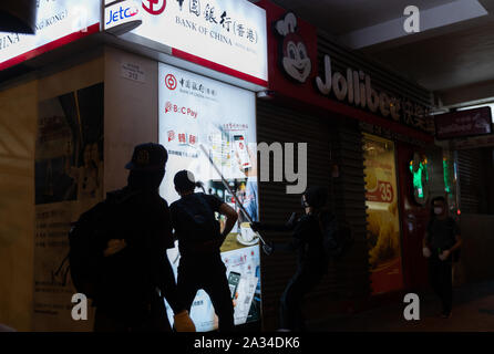 Hongkong, China. 04 Okt, 2019. Demonstranten versuchen, den vorderen Glas Bank von China während einer Demonstration in Hongkong. Nacht der Gewalt mit den Demonstranten über Stadt zu zerschlagen kommt nach der Stadt Chief Executive Carrie Lam kündigt neue Anti-mask Recht. Die Rechtsvorschriften in Kraft, ab 24.00 Uhr am Freitag, den 5. Oktober, 2019. Die Nichteinhaltung des Gesetzes könnte ein Satz von einem Jahr Gefängnis und einer Geldstrafe von HK $ 25.000. Credit: SOPA Images Limited/Alamy leben Nachrichten Stockfoto