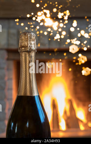 Gemütliche Szene vor dem Kamin mit Flasche Champagner Wein, im Landhaus, Winterurlaub, senkrecht. Stockfoto