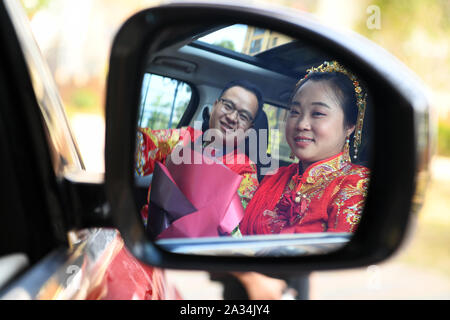 (191005) - TONGREN, Oktober 5, 2019 (Xinhua) - Bräutigam Pan Rongdong (L) und braut Tan Lifei in einer Hochzeit Auto in Tongren Stadt gesehen werden, im Südwesten Chinas Provinz Guizhou, Oktober 4, 2019. Pan Rongdong ist Mitarbeiterin in der mütterlichen und Kinder Gesundheit Service Center in Wanshan Kreis Tongren. Im September 2017, wenn die Pfanne zu Wengbei Dorf Aozhai Gemeinde versandt wurde in Wanshan auf die Verringerung der Armut zu arbeiten, erhielt er mit Tan Lifei, Direktor der anti-Armut station für Aozhai kennen. Bei ihrer Arbeit auf die gezielte Armutsbekämpfung, Pan und Tan geholfen und t Stockfoto