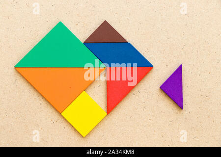 Farbe tangram Puzzle in Herzform, Dreieck Stück auf Holz Hintergrund zu erfüllen, warten Stockfoto