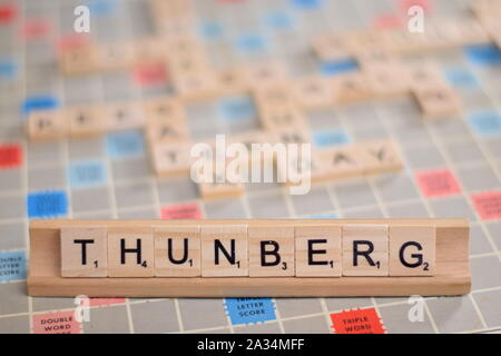 Der Name "thunberg" (Greta Thunberg, ein schwedischer Jugendlicher Umweltaktivist zum Klimawandel). Hintergrund ein Vintage scrabble Board mit kopieren. Stockfoto