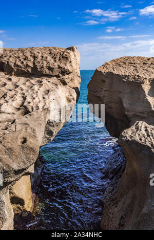 Ein riesiger Felsen am Ufer in Form eines Bogens Stockfoto