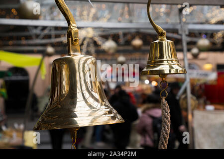 Messing Glocke, ähnlich einem schiffe nautische Bell, hängen für Verkauf von Greenwich Market, an Weihnachten. Greenwich, London. Großbritannien (105) Stockfoto