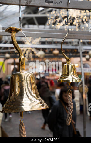 Messing Glocke, ähnlich einem schiffe nautische Bell, hängen für Verkauf von Greenwich Market, an Weihnachten. Greenwich, London. Großbritannien (105) Stockfoto