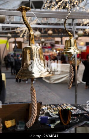 Messing Glocke, ähnlich einem schiffe nautische Bell, hängen für Verkauf von Greenwich Market, an Weihnachten. Greenwich, London. Großbritannien (105) Stockfoto