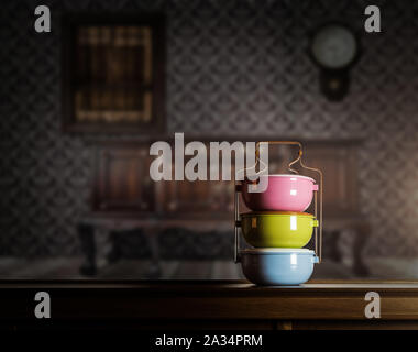 Bunte tiffin Carrier auf Holzschrank mit Vintage Innenraum gegen warmes Licht Stockfoto