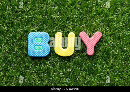 Spielzeug Schaumstoff Buchstaben im Wort kaufen auf grünem Gras Hintergrund Stockfoto