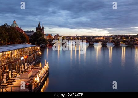 Nacht fällt an der Moldau in Prag, Tschechien. Charles Bridge in der Ferne. Stockfoto