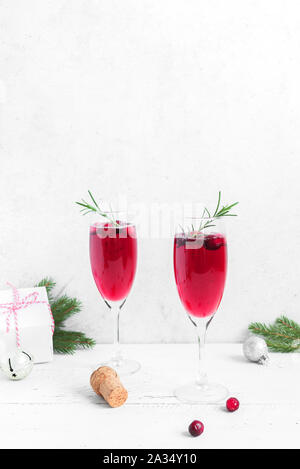 Weihnachten rote cranberry Mimosa mit Rosmarin auf weißem Hintergrund, kopieren. Cocktail mit Sekt für Weihnachten Morgen. Stockfoto