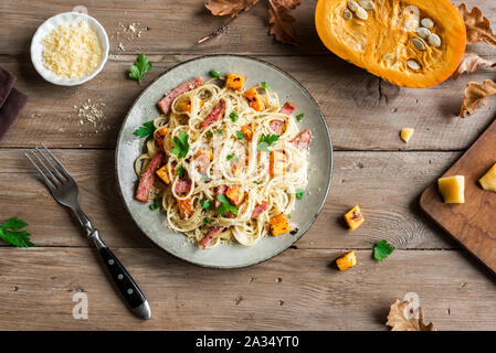 Kürbis und Speck Nudeln mit geriebenem Parmesan. Hausgemachte spaghetti Kürbis Pasta auf Holz, kopieren. Saisonale Herbst essen. Nudeln Kürbis Carbo Stockfoto
