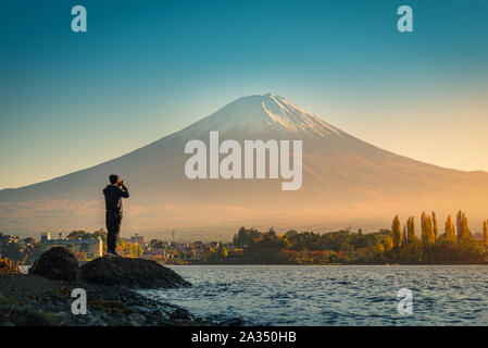 Ansicht der Rückseite des Reisenden Mann Foto Fuji Berg und kawaguchiko See bei Sonnenuntergang in Kawaguchiko, Japan. Stockfoto