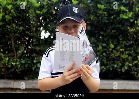 London, Großbritannien. 05 Okt, 2019. Ein junger Fan liest seine Match Day Programm außerhalb der Erde. EFL Skybet championship Match, Fulham v Charlton Athletic im Craven Cottage in London am Samstag, den 5. Oktober 2019. Dieses Bild dürfen nur für redaktionelle Zwecke verwendet werden. Nur die redaktionelle Nutzung, eine Lizenz für die gewerbliche Nutzung erforderlich. Keine Verwendung in Wetten, Spiele oder einer einzelnen Verein/Liga/player Publikationen. pic von Steffan Bowen/Andrew Orchard sport Fotografie/Alamy Live news Credit: Andrew Orchard sport Fotografie/Alamy leben Nachrichten Stockfoto