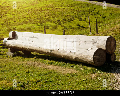 Eine Bank aus Baumstämmen auf der Seite eines Berges. Stockfoto