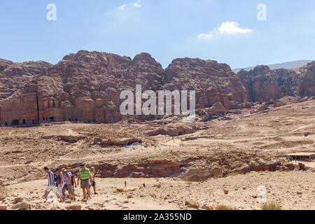 Petra, Jordanien - Sept 21, 2013: Touristen zu Fuß durch ein Tal in Petra mit im Hintergrund das alte Grab Gebäude in den Bergen geschnitzt Stockfoto
