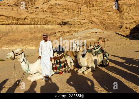 Wadi Rum, Jordanien - Sept 22, 2013: Arabische Lokale mit seinen Kamelen mit Kamelritt durch die Wüste Wadi Rum. Im Vordergrund Schatten von Touristen l Stockfoto