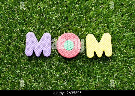 Spielzeug Schaumstoff Buchstaben im Wort Mama auf grünem Gras Hintergrund Stockfoto