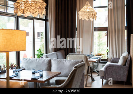 Innenraum der luxuriösen Restaurant mit weichen grauen samt Sofas und Tische Stockfoto