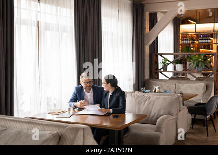 Zwei erfolgreiche Geschäftspartner besprechen Papiere und die Beratung bei der Konferenz Stockfoto