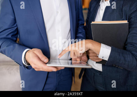 Elegante Geschäftsfrau über elektronische Dokument mit Geschäftsmann Stockfoto