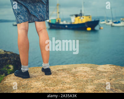 Die Beine einer jungen Frau, die in einem Hafen Stockfoto