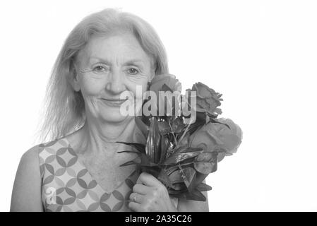 Studio shot der älteren Frau mit roten Rosen Stockfoto