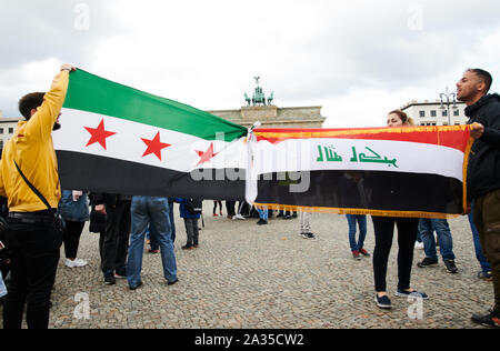 Berlin, Deutschland. 05 Okt, 2019. Die Demonstranten halten die Flagge des Irak (1963-1991, l) und die aktuelle Nationalflagge mit Inschrift vor dem Brandenburger Tor. Es Menschen demonstrierten gegen die Politik im Irak. Quelle: Annette Riedl/dpa/Alamy leben Nachrichten Stockfoto