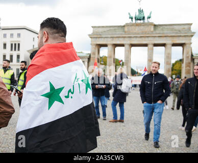 Berlin, Deutschland. 05 Okt, 2019. Ein Demonstrator mit einem irakischen Flagge steht vor dem Brandenburger Tor. Es Menschen demonstrierten gegen die Politik im Irak. Quelle: Annette Riedl/dpa/Alamy leben Nachrichten Stockfoto